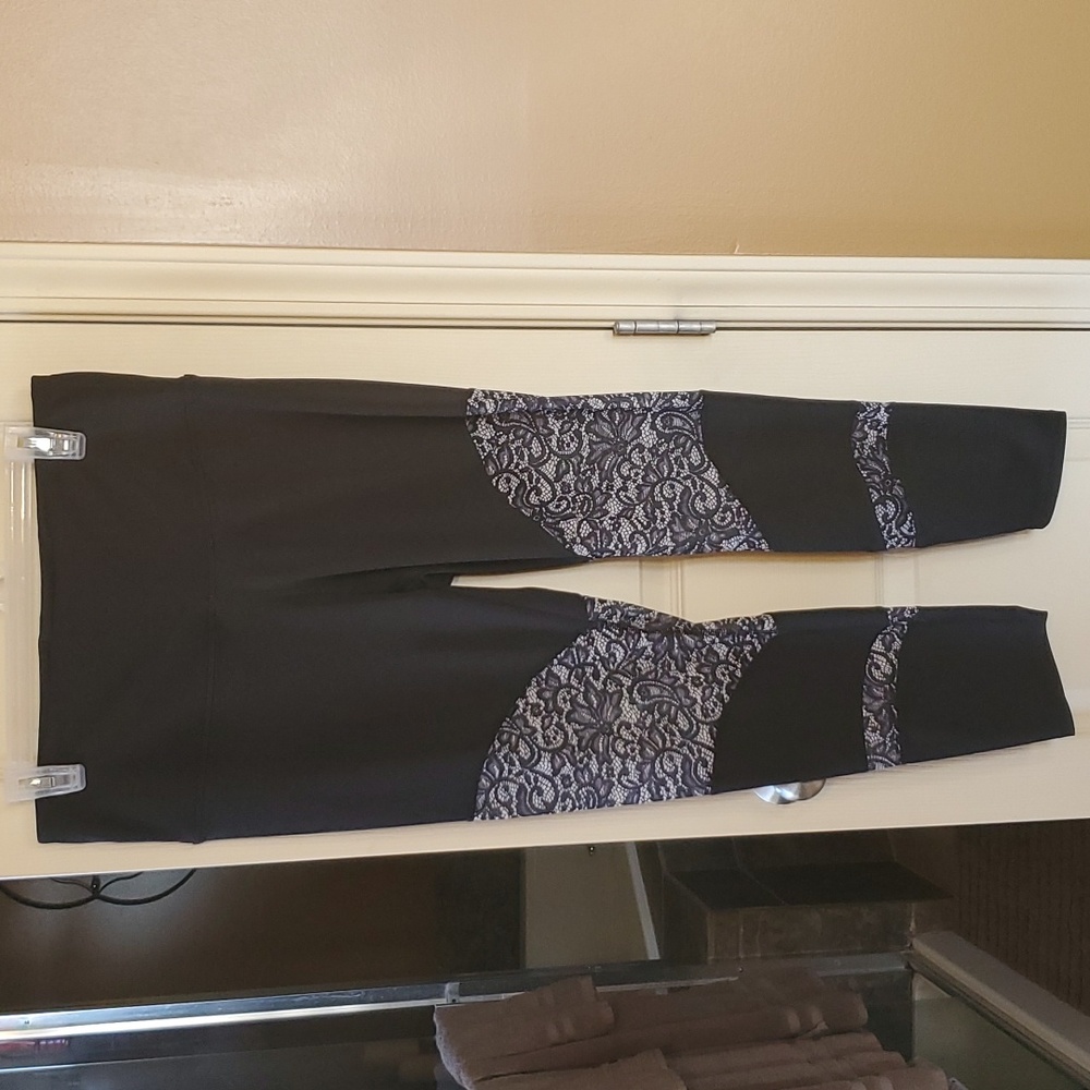 Black yoga/exercise pants with lace pattern around knees.